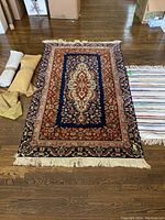 Overview of wool area rug, rag runner, and under pads on hardwood floor