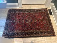 Top view of rectangular hand woven wool carpet showing full length and detailed border patterns.