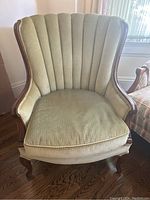 Front view of the vintage arm chair showing scalloped channel back, cushioned seat, and detailed wooden frame.