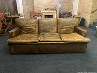 Front view of entire sofa showing overall shape, cushion sagging, and finish wear