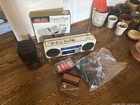 Photo showing the Uniden phone box, Sony stereo cassette player, several small items including record cleaning accessories and a bag with headphones.