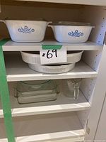 Clear glass rectangular baking dishes on a lower shelf, one has a handle.