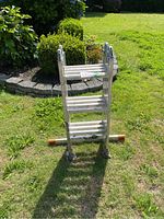Photo showing the folded Krause extension ladder standing upright on grass, with orange foot caps visible and a price tag attached.