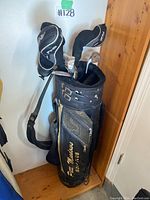 Full view of the black golf bag with clubs inside, bag labeled 'Pitt Meadows Golf Club'