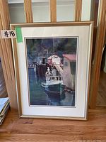 Framed print of tugboat dock scene, showing full frame and surrounding area.