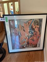 Full view of large framed Picasso print leaning on hardwood floor