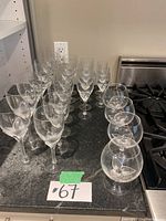 Angle view showing a group of tall wine glasses and shorter snifter glasses on countertop