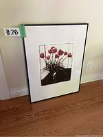 Framed photographic print of red tulips leaning against wall, showing full artwork and frame.