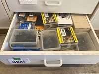 Drawer containing multiple plastic containers and boxed packs of black construction screws from Ace Dura-Grip line.