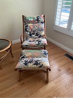 Bamboo chair and ottoman shown from a frontal angle, clearly displaying floral cushions and bamboo frame.
