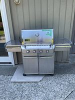 Front view with hood closed showing four control knobs and side shelves