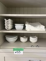 Shelving with bowls of different sizes and cloth napkins, showing quantity and condition of lot