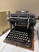 Front angled view showing keyboard, carriage,"Remington" brand letters on front.