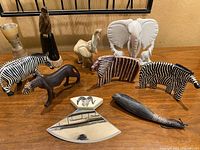 Front view of all carved wood and natural stone animal figurines and decorative items arranged on wooden surface