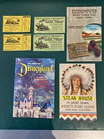 Photo showing the full lot of 1955 Disneyland guide booklet, four vintage Disneyland tickets, and two Knott's Berry Farm pamphlets.