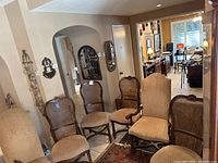 Photo showing six Thomasville dining chairs in a room; mix of wicker-backed and upholstered-backed chairs with beige fabric seats and dark wood frames.