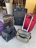 Overview of six suitcases and travel bags of various styles and colors, showing the assortment in different sizes and conditions.