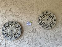 Both thermometer and clock hanging on textured exterior wall showing full lot contents