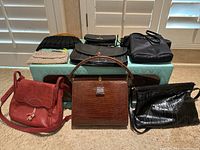 All vintage purses arranged on and in front of a mint green quilted vintage case showing variety, materials, and condition.