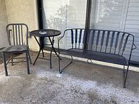 Full set showing small round table with metal IKEA chair and wrought iron bench on patio