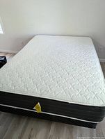 Full view of the full size mattress, showing the white quilted pattern on top with black sides.