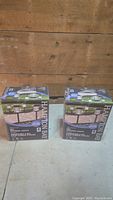 Two unopened boxes of Hampton Bay LED solar pathway lights, each box contains 6 lights.