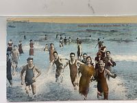 Front view of Bathers' Delight at Coney Island postcard showing people in historic bathing suits wading in the ocean.