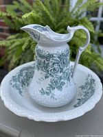 Water jug placed inside basin outdoors, showing overall condition and design of both pieces.