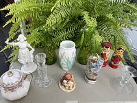 Overview of the lot showing all items arranged on a table with fern plant background.