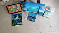 Full view of all six paintings displayed on the floor showing size variations and tropical themes