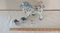Ceramic collectibles including a painted horse figurine and two small Asian inspired children figurines on a flat surface with a ruler for scale.