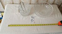 Wide view showing cut crystal bowl, cut crystal ice bucket with metal tongs, and measuring tape for scale.
