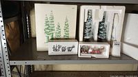 Shelf display of Department 56 North Pole Village accessories including boxed sets and snow-covered tree figurines in original packaging.