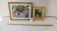 Two framed autumn landscape paintings with measuring ruler showing size
