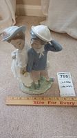 Front angle showing the boy and girl figurine holding hands with ruler indicating approximately 7 inches tall.