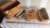 Wide shot showing six Longaberger baskets of various sizes including lidded baskets, fabric inserts in pastel colors, and a large handled basket.