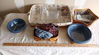 Assortment of Longaberger baskets with fabric and plastic inserts on white surface along with measuring ruler.