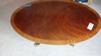 Top view of the oval wooden coffee table showing wood grain and lighter wood border