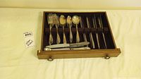 Wooden drawer box with silver plated forks, spoons and knives arranged neatly inside velvet compartments, photo shows full set.