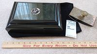 Black lacquer display box with silver dragon medallion, black velvet pouch, brass pen rest and lot tag on ruler