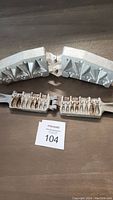 Two metal fishing weight molds opened showing multiple cavities of different sizes and shapes for fishing weights
