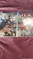 Two Justice League of America comic books, one with Wonder Woman and Aquaman on cover, the other a JLA titled comic
