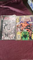 Two comic books visible: one black and white cover and Alpha Flight issue from Marvel Comics Group