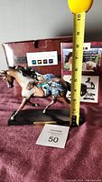 Photo showing entire figurine, tape measure next to horse showing approx 6.5 inches tall, with original box and paperwork in background
