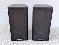 Pair of vintage Precision Acoustics bookshelf speakers shown from front with black fabric grill covers and logo plates