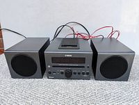 Front view of Yamaha micro component system showing main unit and two speakers on carpet