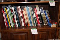 Books on a wooden shelf showing various military history and regional titles, slightly worn covers.