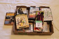 Photo of the box containing assorted used DVD movies including Looney Tunes and Great Trains of America.