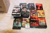 Photo showing a collection of various DVDs including titles such as District 9, Korea: The Forgotten War, Ratatouille, The Italian Job, 11:14, The Departed, Guys and Dolls, a Rolling Stones box set, and WAR in Color box set.