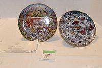 Two McDonald's Franklin Mint collector plates shown side by side, with a certificate or paper to the left and a lot number card in front